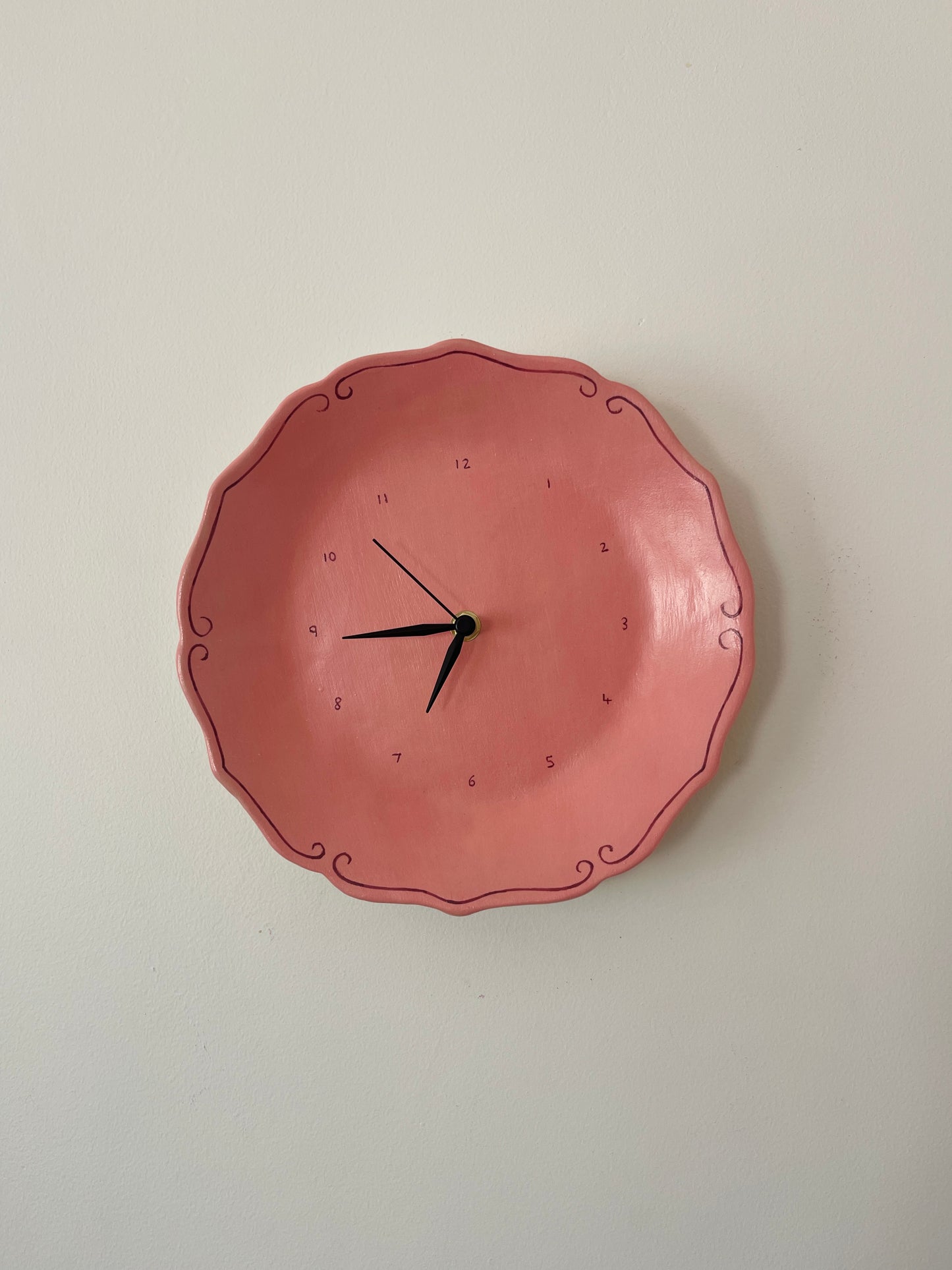 Pink ceramic clock with curlicues