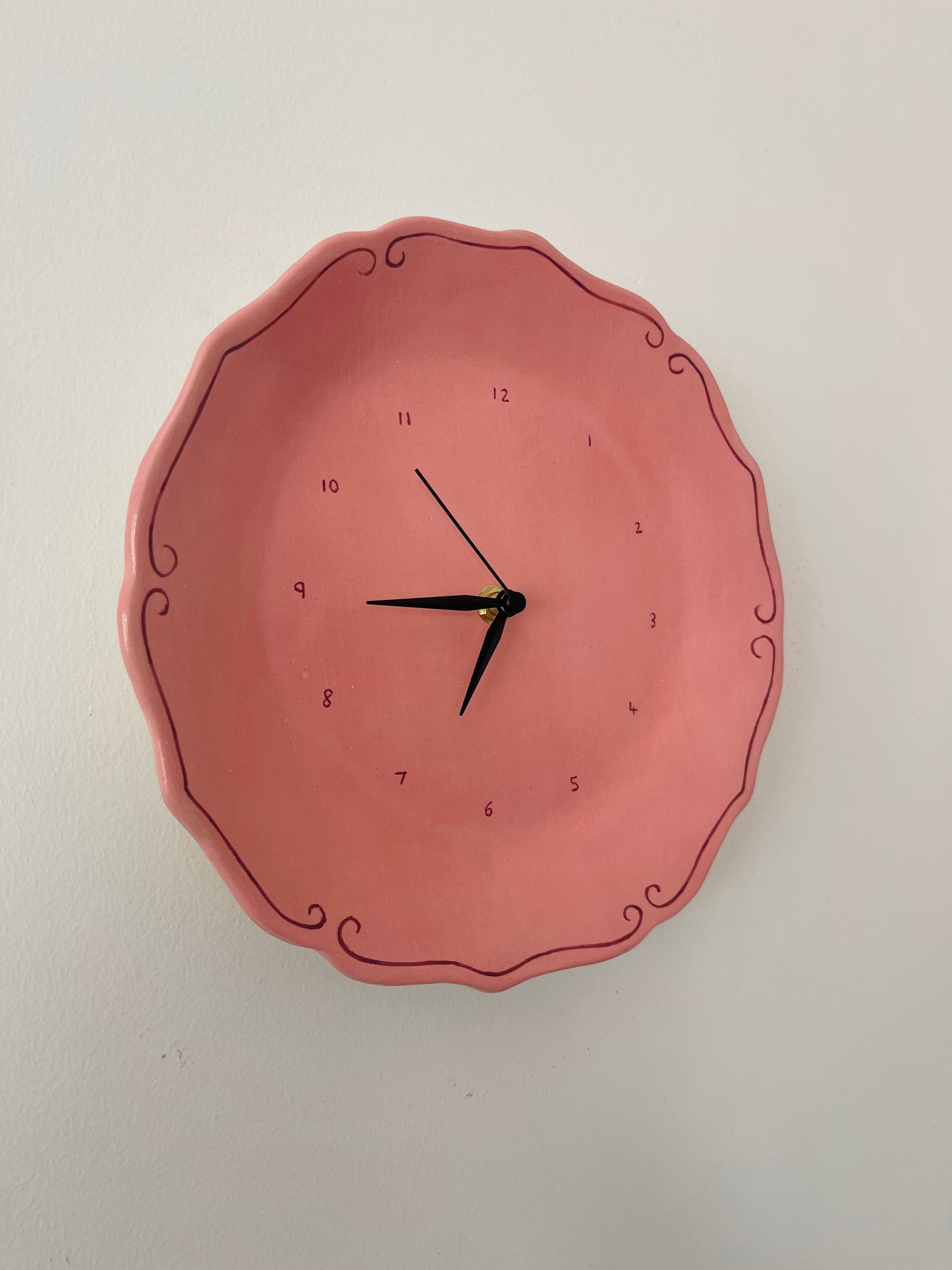 Pink ceramic clock with curlicues
